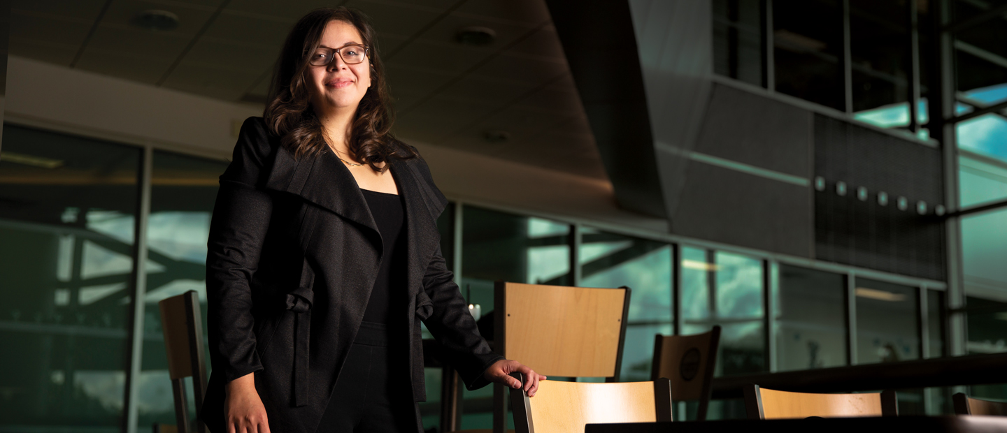 Image of a college aged girl standing and smiling at the camera